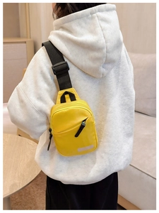 Close-up of bright yellow nylon chest bag with safety reflective strip and adjustable strap