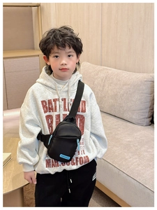 Detail of kids black chest bag with light blue logo and adjustable nylon strap
