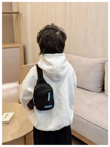 Detailed back view of a child wearing a black nylon chest bag with blue TONGHUO logo