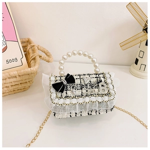 Detail of tweed crossbody bag with pearl handle, bow decoration and gold chain strap