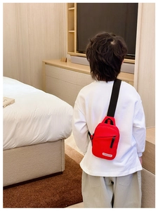 Close-up of a red kids crossbody bag with adjustable strap and TONGHUO logo detail
