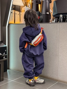 Détail d'un ensemble à capuche marine pour enfant avec un sac banane en patchwork coloré