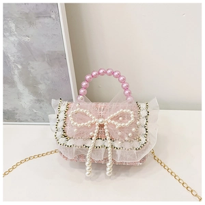 Detail of pink tweed girl's bag with pearl handle, bow decoration and gold chain strap
