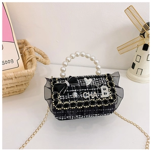 Detail of tweed mini crossbody bag with pearl handle and elegant mesh ruffle trim