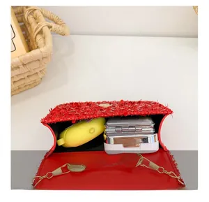 Detail view of the red sequin bag interior holding a compact and earphone case