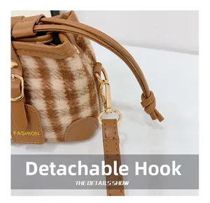 Close-up of plush striped bucket bag featuring detachable gold metal hooks and fashion logo