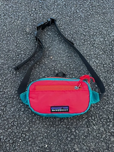 Détail du sac de poitrine pour enfants en nylon avec couleurs contrastées et logo montagne