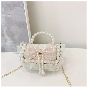 Detail of tweed girl's purse featuring large pink mesh bow and elegant pearl handle