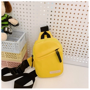 Detailed view of yellow nylon kids chest bag with pink label and black strap