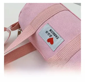Close-up of pink canvas bucket bag with fashion bag patch and woven strap details