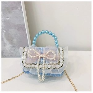 Detail of blue plaid tweed bag with pearl handle, lace trim and mesh bow accents
