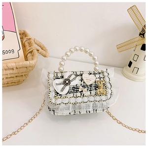 Detail of tweed kids crossbody bag with pearl handle, lace trim, and lovely heart charm