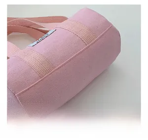 Detailed macro view of pink canvas bucket bag with high-quality stitching and woven labels