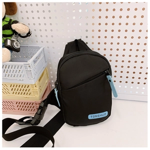 Detail of a black sporty chest bag for boys with blue accents and adjustable strap