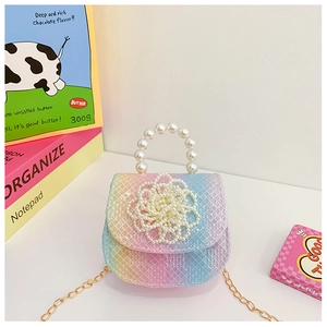 Detail view of rainbow gradient girl's handbag with large pearl flower and gold chain