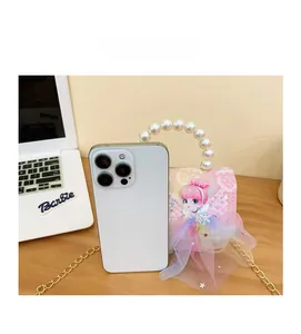 Pink sequin mini handbag for girls with pearl handle next to phone for size scale