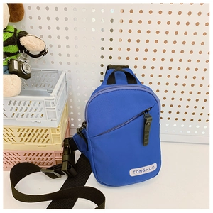 Detail of blue nylon crossbody bag featuring front zipper pocket and adjustable black strap