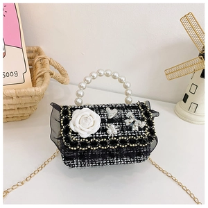 Detail of tweed crossbody bag with pearl handle, camellia charm and black lace trim