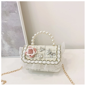 Detail of tweed girls handbag with pearl handle and pink camellia flower decoration