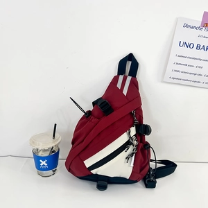 Detailed view of red and white triangular sling bag with durable buckles and drawstrings