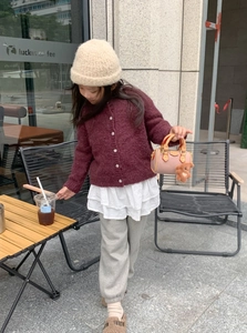 Dettaglio della mini borsa a cilindro rosa con un ciondolo a forma di orsetto