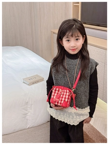 Close-up of red and white checkerboard kid's bucket bag with fashion embossed flap