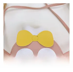 Gros plan détaillé du sac lapin en cuir PU rose avec nœud jaune et coutures soignées