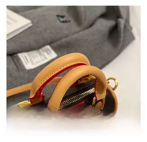 Gros plan d'un mini sac cylindre rétro avec poignées en cuir marron et fermeture éclair dorée