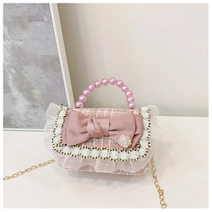 Detailed view of pink tweed kids handbag with pearl handle and rose bow decoration
