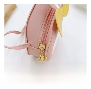 Détail du sac enfant en similicuir rose avec fermeture éclair fleur dorée et ailes
