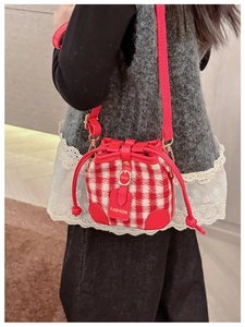 Close-up of kids mini gingham bucket bag with red leather trim and fashion tag detail