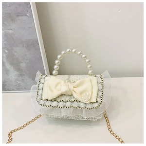 Detail of tweed girls purse with pearl handle, satin bow and camellia flower