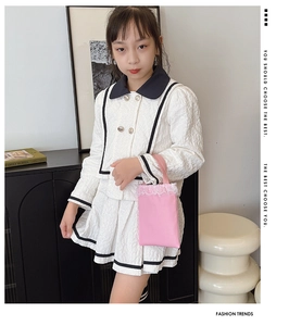 Detail view of girls' white quilted two-piece set with black trim and gold buttons