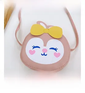 Gros plan détaillé d'un sac à bandoulière lapin rose avec un nœud jaune et des broderies