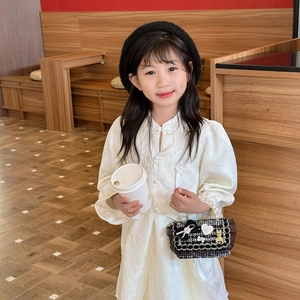 Girl in white lace qipao dress with pearl cuffs and black beret in a cozy cafe setting