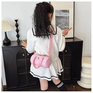 Detailed shot of pink canvas bucket bag with fashion patch and adjustable strap
