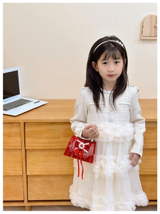 Close-up of white tweed dress with silver buttons and tiered tulle skirt for girls