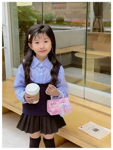 Pink pearl handle mini bag styled with a girls autumn navy knit and pleated skirt set