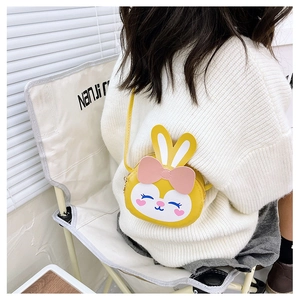 Fillette portant un sac à bandoulière lapin jaune mignon avec nœud rose