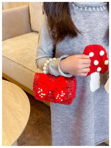 Detail of red sequined girls purse with pearl handle and silk bow for festive events