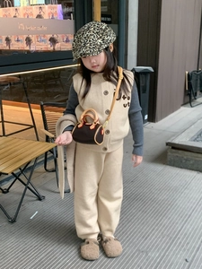 Dettaglio di una mini borsa marrone con cuciture di qualità per un outfit invernale retrò da bimbi