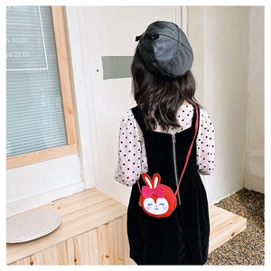 Sac bandoulière enfant rouge motif lapin mignon porté par un mannequin en intérieur