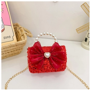 Close-up of kids red sequin handbag with pearl handle and satin bow detail