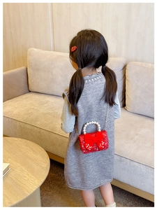 Detail of red festive sequin crossbody bag with pearl handle and ribbon bow for girls