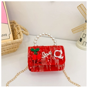 Detail of red sequined kids handbag with pearl handle, cherry motifs and gold chain strap