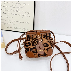 Detail of leopard print bucket bag with leather trim and gold hardware accents