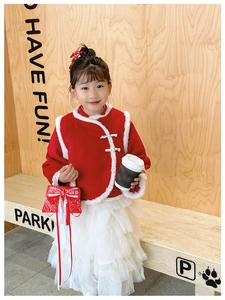 Detail of red fur-trimmed traditional top and white layered tulle skirt for girls