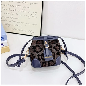 Close-up of leopard print bucket bag with navy leather trim and gold metal accents