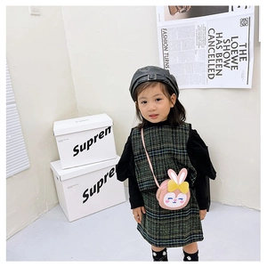 Détail du sac à bandoulière en peluche lapin rose avec nœud jaune et robe à carreaux