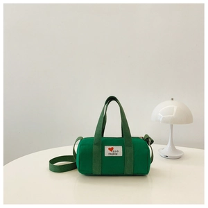 Detail of green canvas bucket bag with heart patch and adjustable shoulder strap